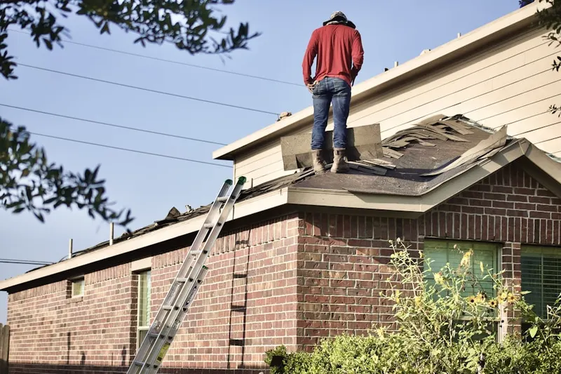 Professional roofer working on a residential roof in Masury